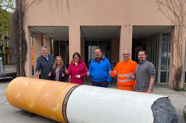 Hinter der 6m langen Kippen-Skulptur zu sehen: Simone Schmidt, Leitung der Kinder- und Jugendgruppen des Bund Naturschutz in Garching, zusammen mit dem scheidenden Bürgermeister Dietmar Gruchmann, Dagmar Bahmet-Trcka & Ralf Gutknecht (beide Umweltreferat) und zwei Mitarbeitern des Garchinger Bauhofs, die den Transport aus Burghausen ermöglicht haben