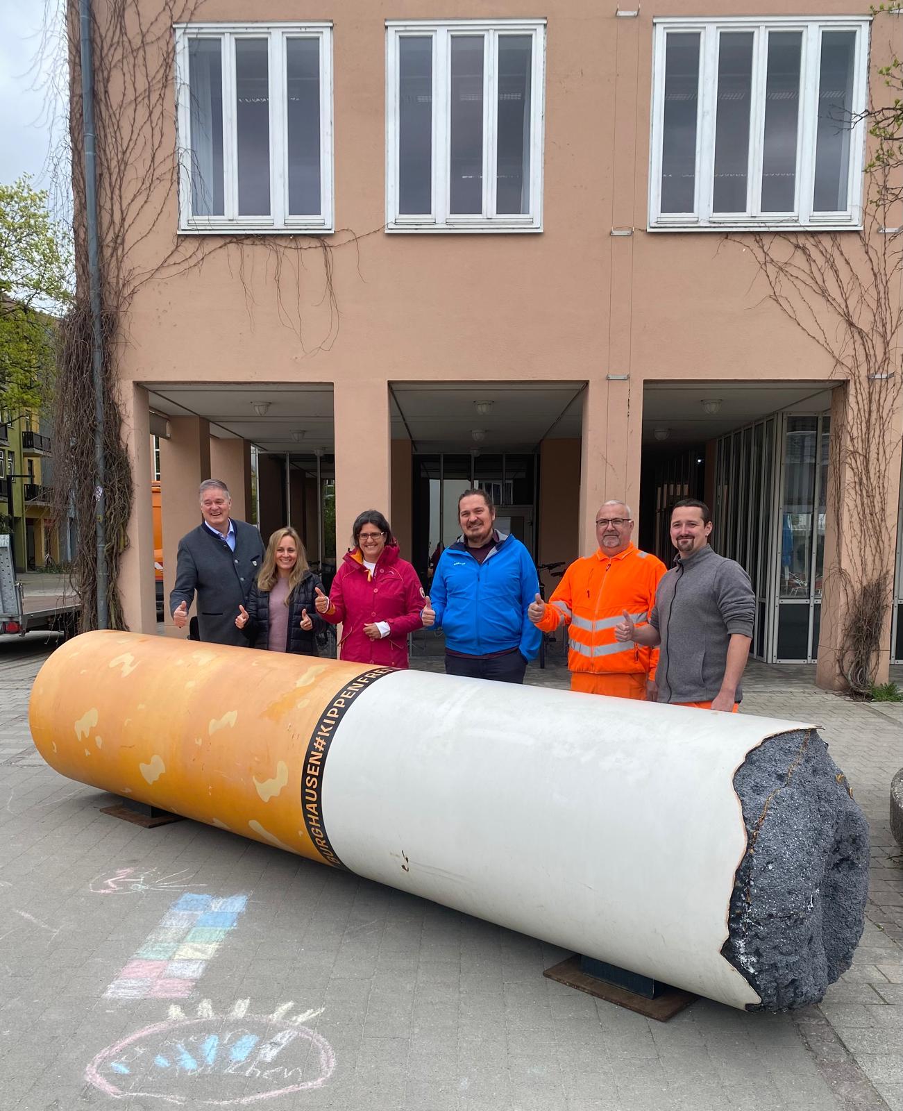 Hinter der 6m langen Kippen-Skulptur zu sehen: Simone Schmidt, Leitung der Kinder- und Jugendgruppen des Bund Naturschutz in Garching, zusammen mit dem scheidenden Bürgermeister Dietmar Gruchmann, Dagmar Bahmet-Trcka & Ralf Gutknecht (beide Umweltreferat) und zwei Mitarbeitern des Garchinger Bauhofs, die den Transport aus Burghausen ermöglicht haben